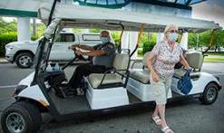 Courtesy cart at Main Entrance with masked patient stepping off cart